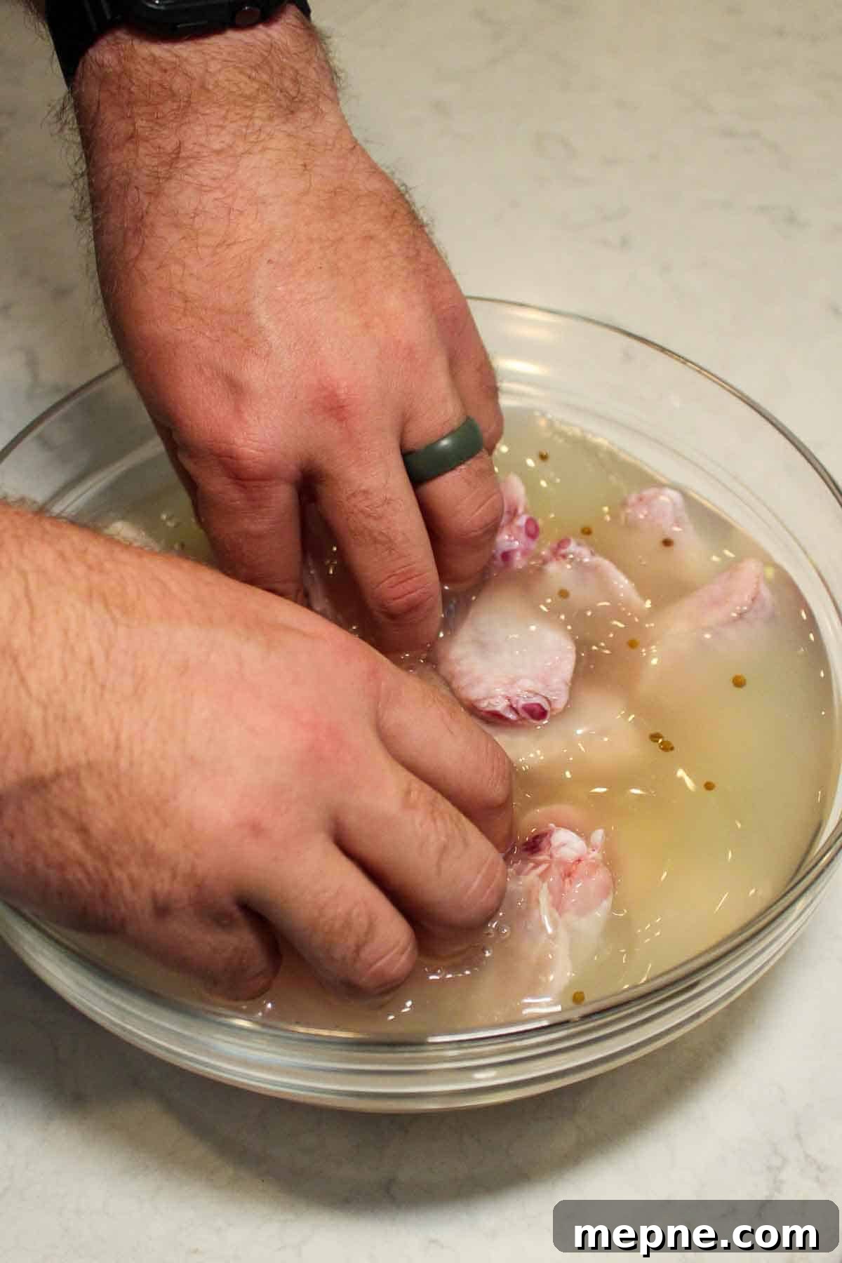 Adding the chicken wings to the pickle brine.