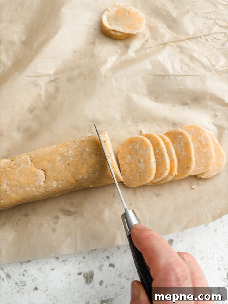 Savory Southern Pecan Cheese Wafers Recipe 6 The wafer dough being sliced thinly