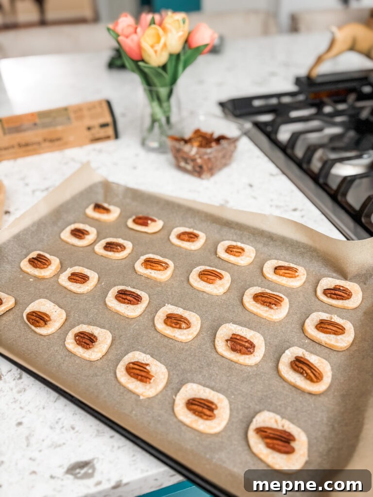 Savory Southern Pecan Cheese Wafers Recipe 7 The slices of dough being topped with pecans