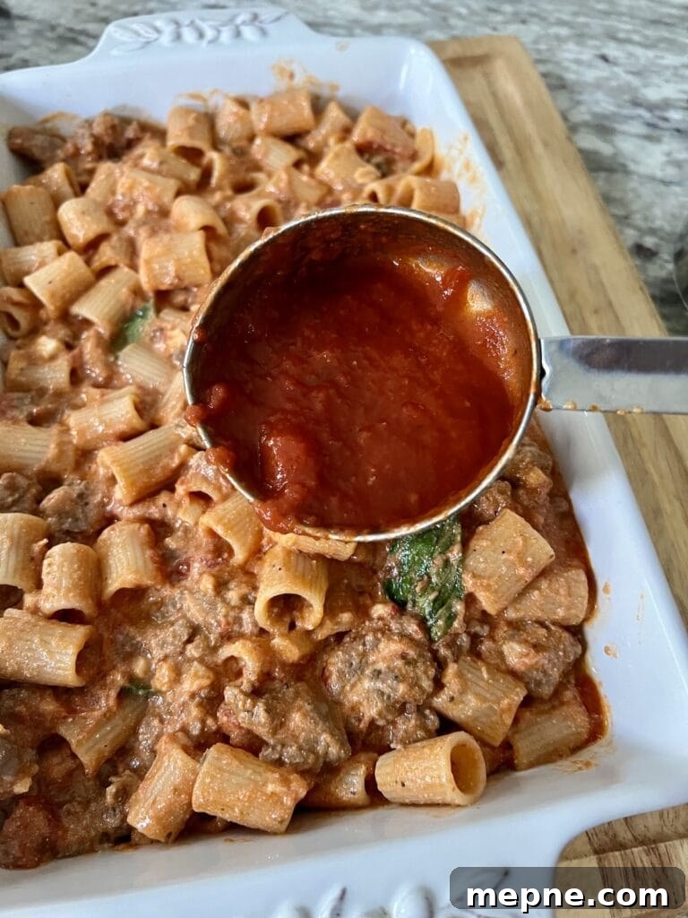 Adding tomato sauce to the baking dish.