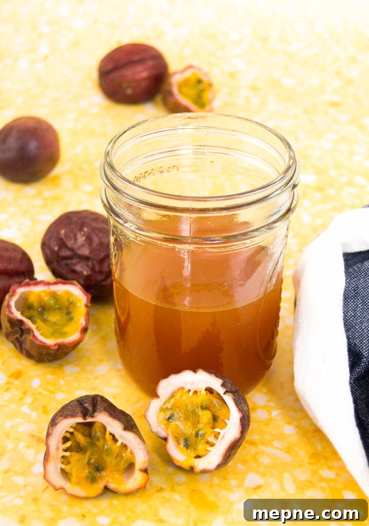 Homemade Passion Fruit Sauce Recipe for Desserts 6 a mason jar of passion fruit sauce in a jar sitting on a yellow surface with purple passion fruits