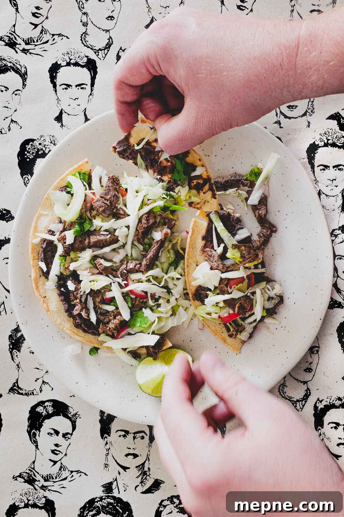 Mexican Tlayudas Hands breaking up a Mexican tlayuda