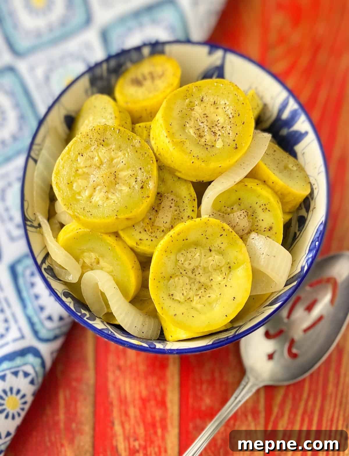 Southern Sauteed Yellow Squash with Caramelized Onions 5 Close up image of sauteed yellow squash and onions in decorative blue and white serving bowl.
