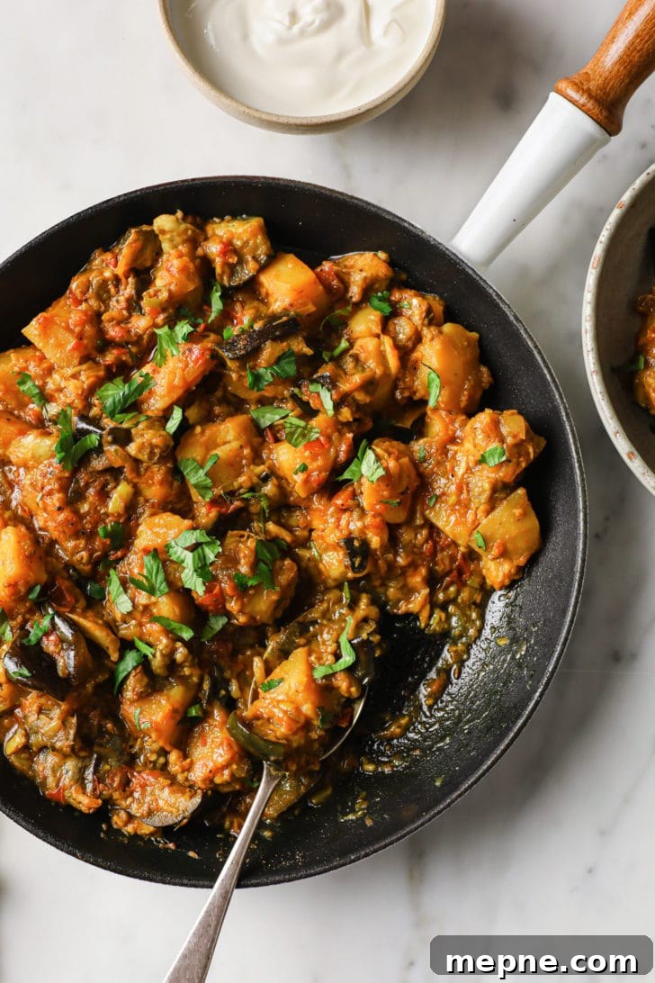 Aloo Baingan: Indian Eggplant and Potato Curry 12 A close up of Eggplant and Potato Curry in a skillet