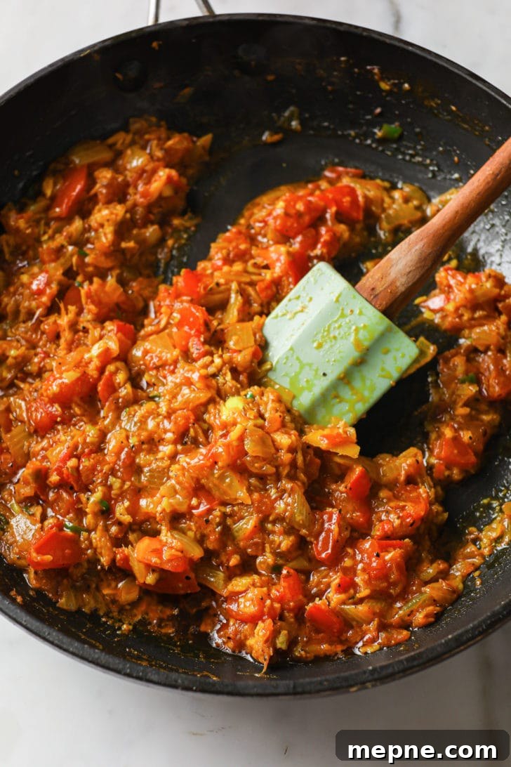 Aloo Baingan: Indian Eggplant and Potato Curry 9 Tomatoes being sautéd in a skillet