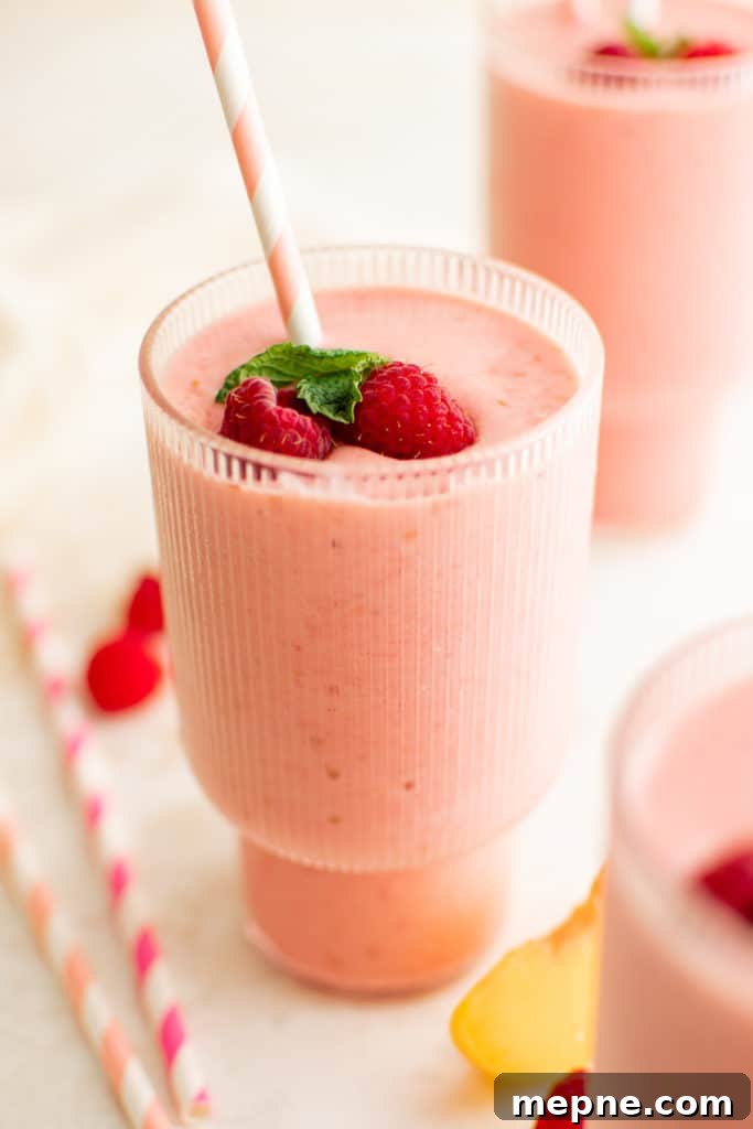 Creamy Peach and Raspberry Smoothie Recipe 2 Tall glass containing a peach raspberry smoothie.