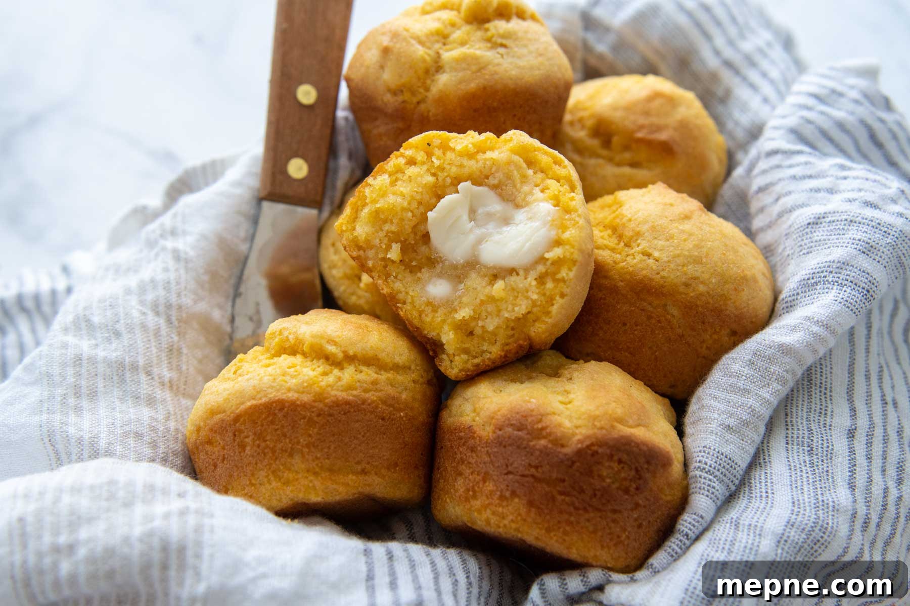 Moist Gluten Free Corn Muffins Recipe 8 an open cornbread muffin with melting butter spread inside