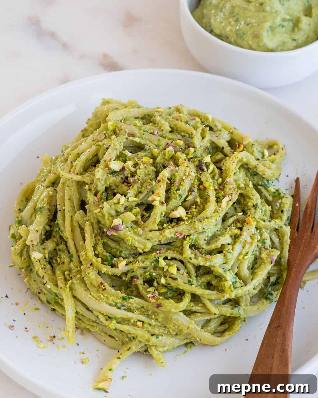 Creamy Avocado Pesto Pasta Recipe 9 completed avocado pesto plated on a white plate against a white background