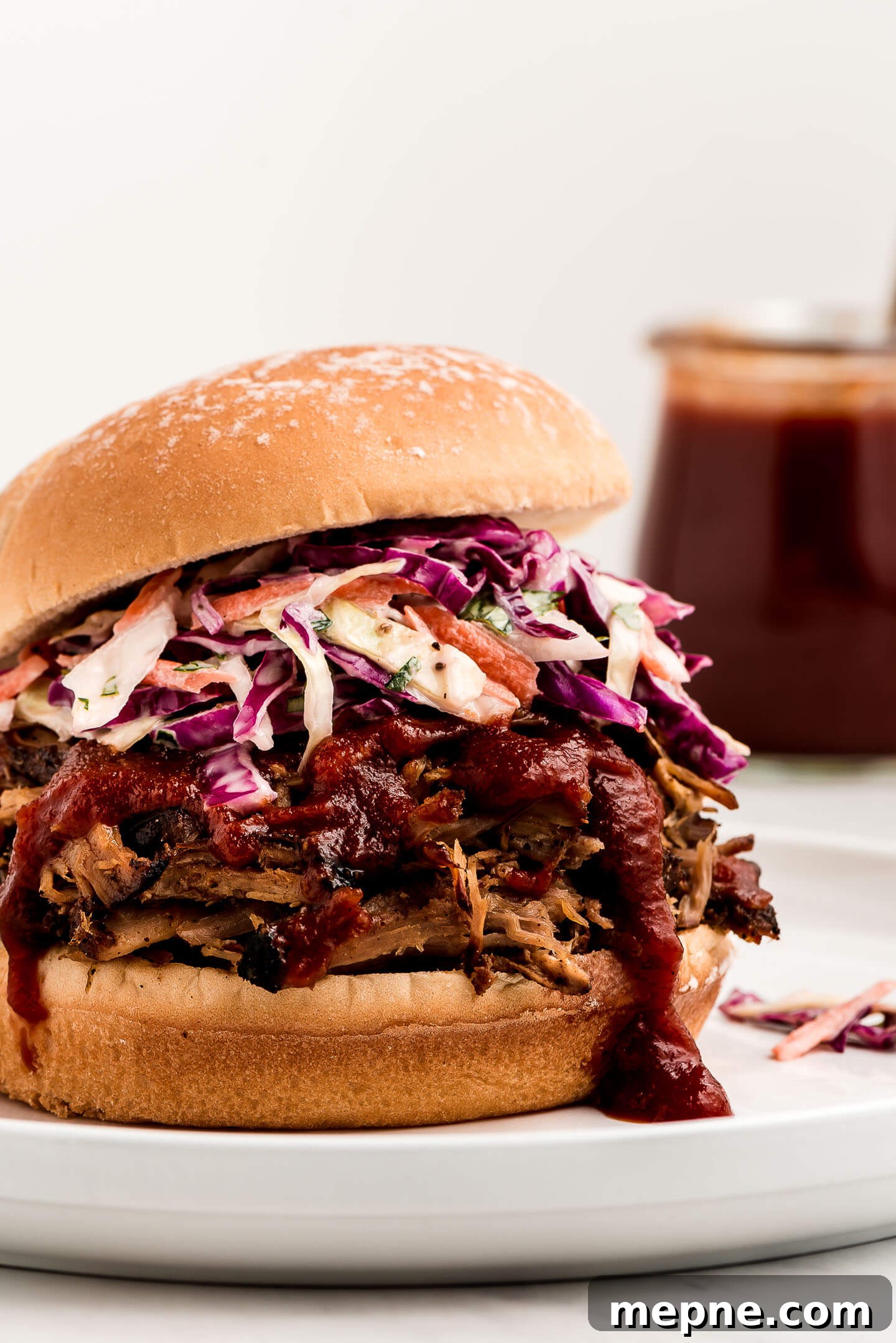 A close up shot of a pulled pork sandwich with coleslaw on it.