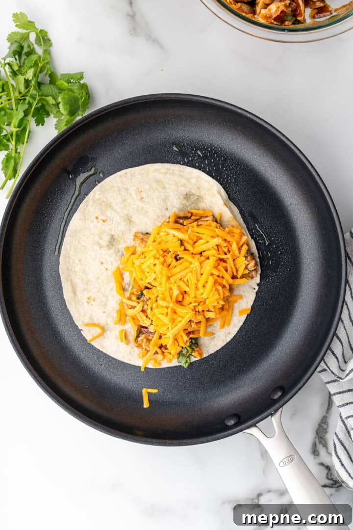 tortilla on pan filled with bbq chicken and cheese