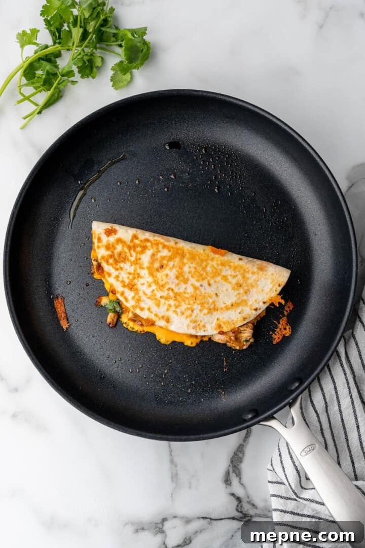 flipped quesadilla on pan cooking