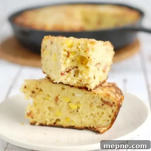 Smoked Side Dishes for BBQ and Cookouts 18 A slice of cornbread on a plate with a skillet in the background