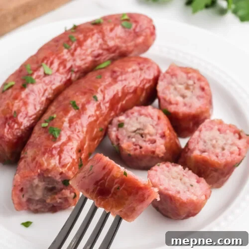 Smoked Side Dishes for BBQ and Cookouts 9 Sausage on a fork with parsley on a white plate