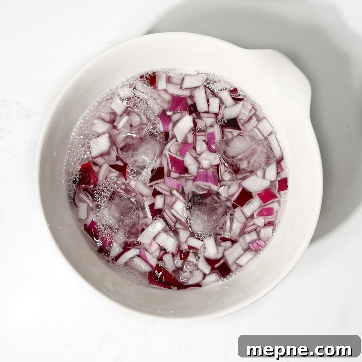 Tangy Indian Onion Chutney to Serve with Poppadoms 5 Chopped onions soaking in a bowl of ice water.