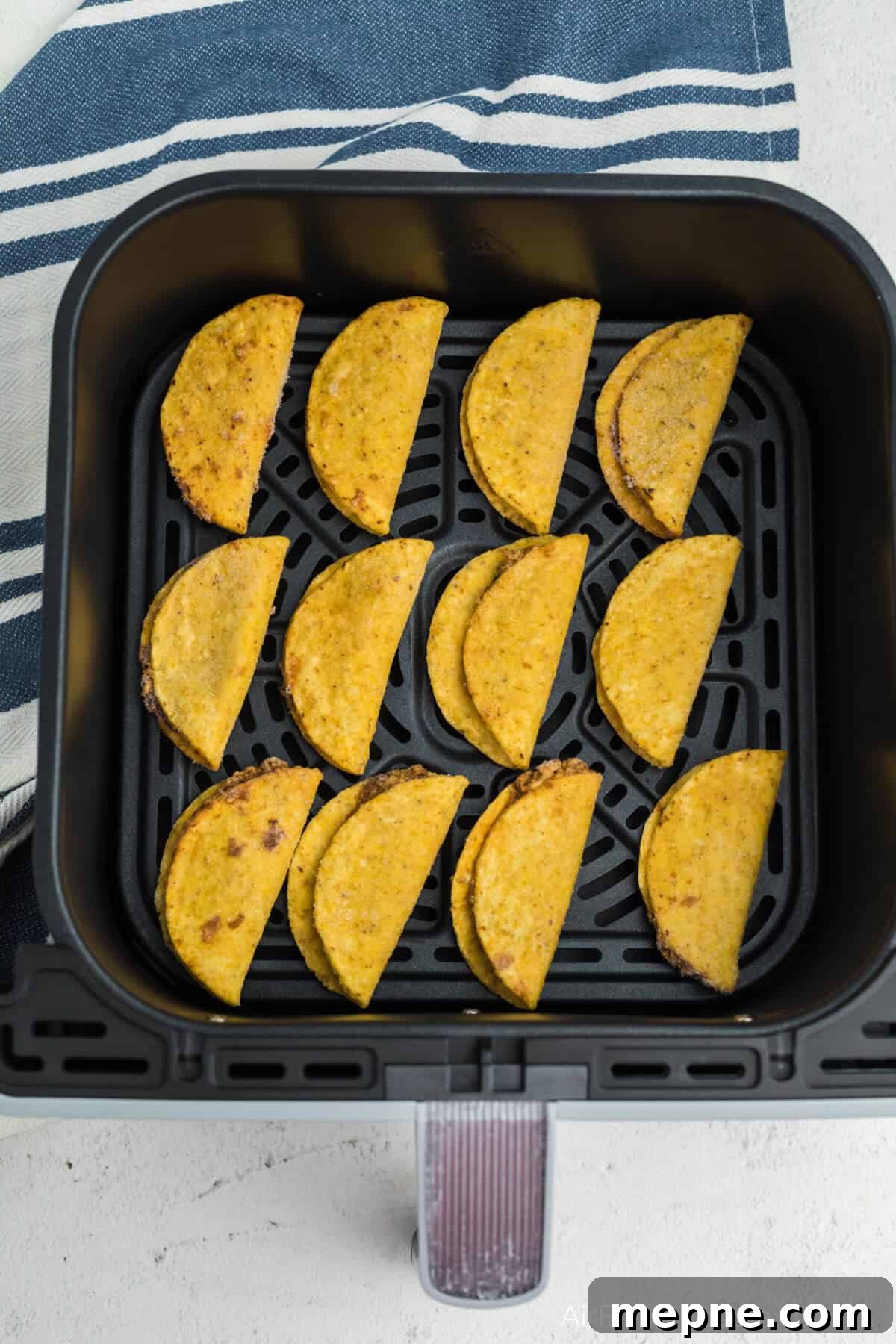 Air Fryer Frozen Mini Tacos: Crispy in Minutes 4 Frozen mini tacos in air fryer basket, ready to be air fried.