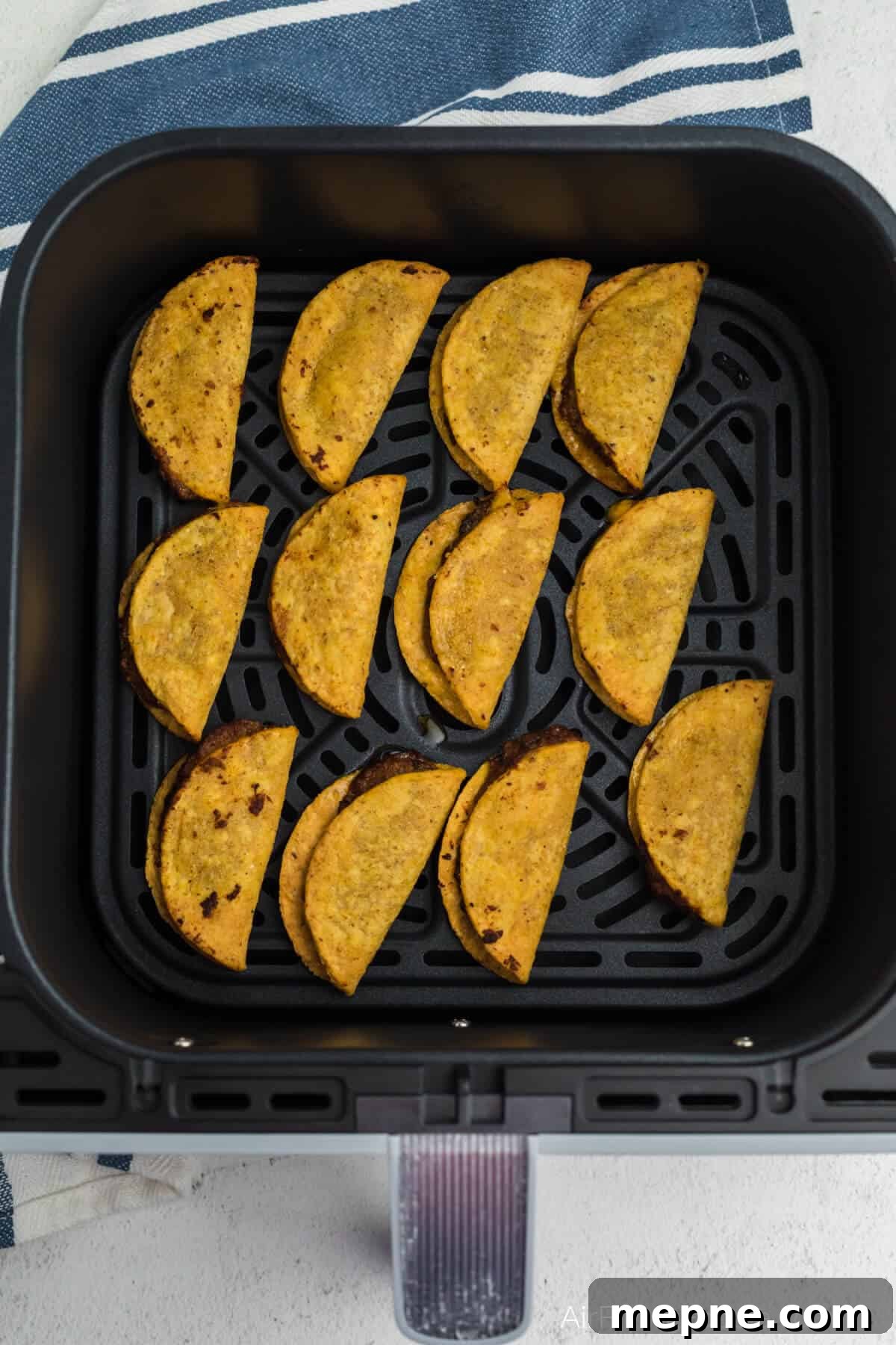 Air Fryer Frozen Mini Tacos: Crispy in Minutes 5 Frozen mini tacos air fried until fully cooked and golden brown, in basket of the air fryer.