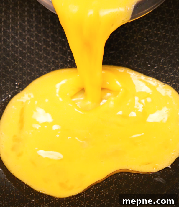 pouring whisked eggs into pan for egg fried rice – beginner-friendly cooking step