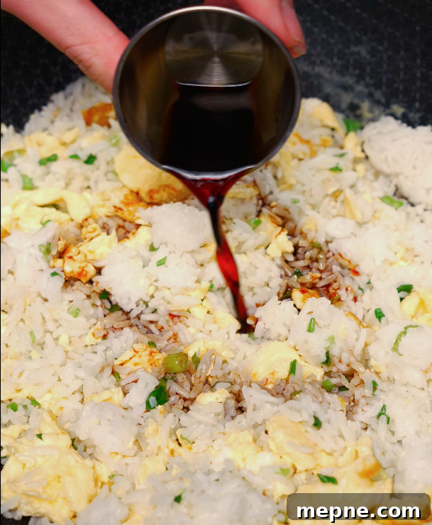 adding soy sauce to egg fried rice – classic Chinese fried rice flavor