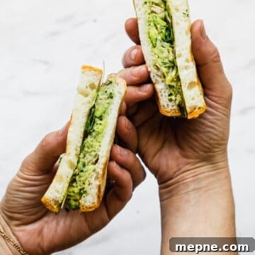 avocado and tuna salad in a sandwich being held