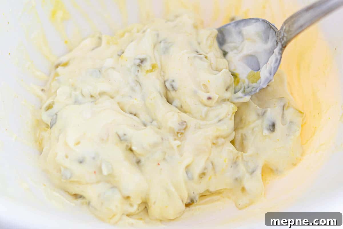 Ham and Egg Salad Recipe with Creamy Dijon Dressing 5 creamy mayo, pickle relish, and mustard dressing in a bowl.