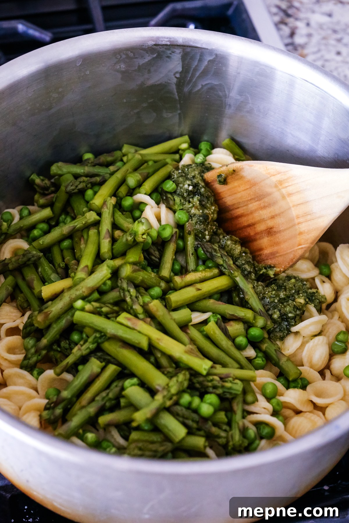 Orecchiette with Pesto, Asparagus and Spring Peas 6 adding asparagus and peas to pasta and stirring them in