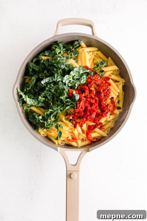Sun-Dried Tomato and Kale Pasta Recipe 4 Pasta with sun dried tomatoes and kale in a skillet.