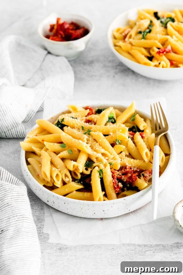 Sun-Dried Tomato and Kale Pasta Recipe 8 Sun dried Tomato and Kale Pasta in a white bowl with a fork.