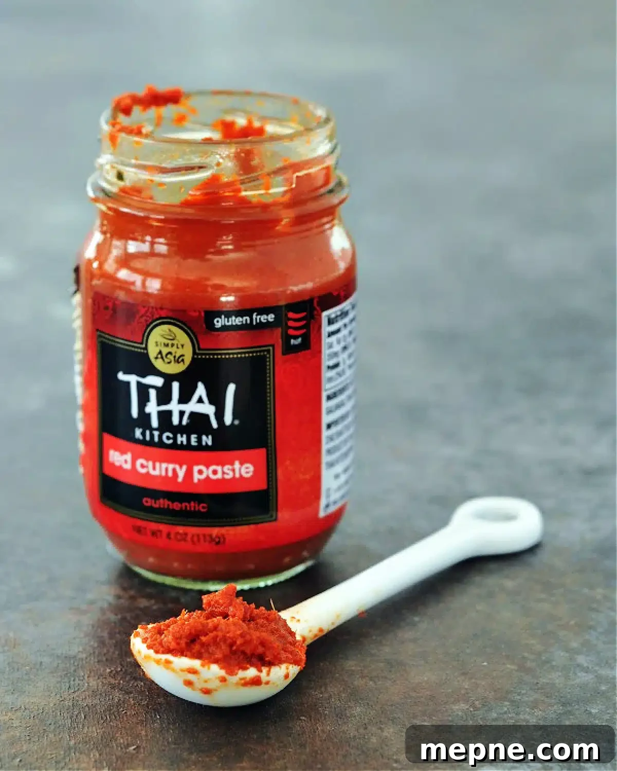 Savory Red Curry Chia Pudding @spabettie #glutenfree #lowcarb #vegan #dairyfree #recipe Open jar of red curry paste with small white ceramic spoon full of curry paste next to the jar.