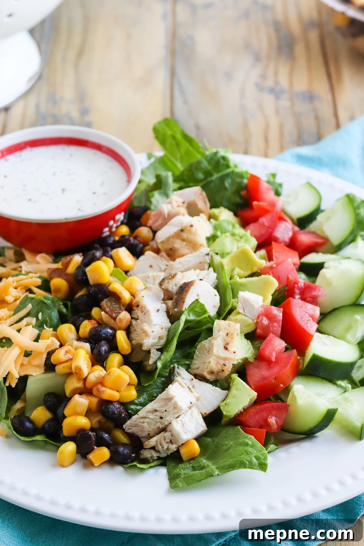 Grilled Chicken Fajita Salad Recipe with Avocado & Lime 4 Close up of a plate with mixed greens, black bean salsa, grilled fajita chicken, tomatoes and ranch.