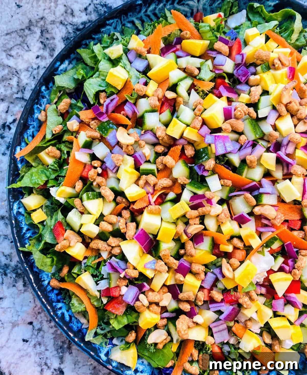 Asian Chopped Salad Recipe with Sesame Ginger Dressing 2 Asian chopped salad on a platter toped with peanuts.