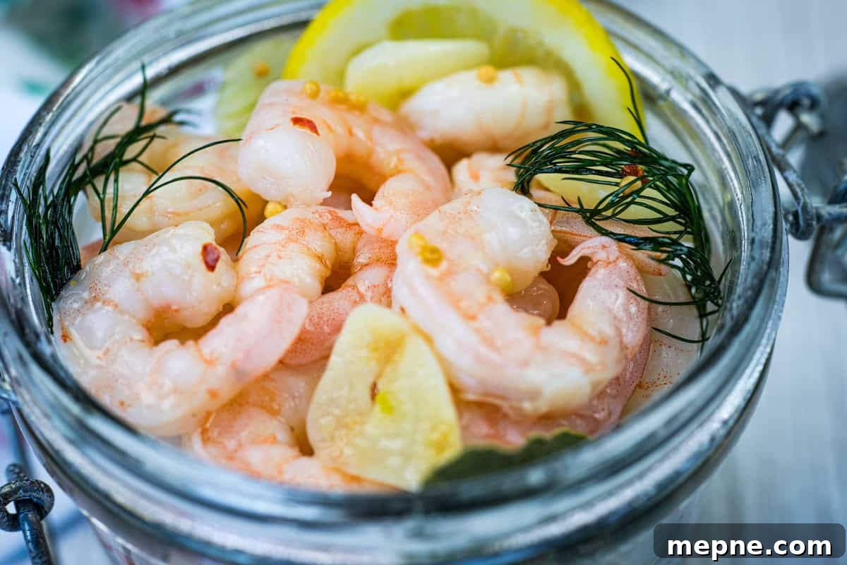 31 Southern Recipes That Belong in Your Dinner Rotation 20 Close-up Southern Style Pickled Shrimp with lemon slices and dill on a jar.