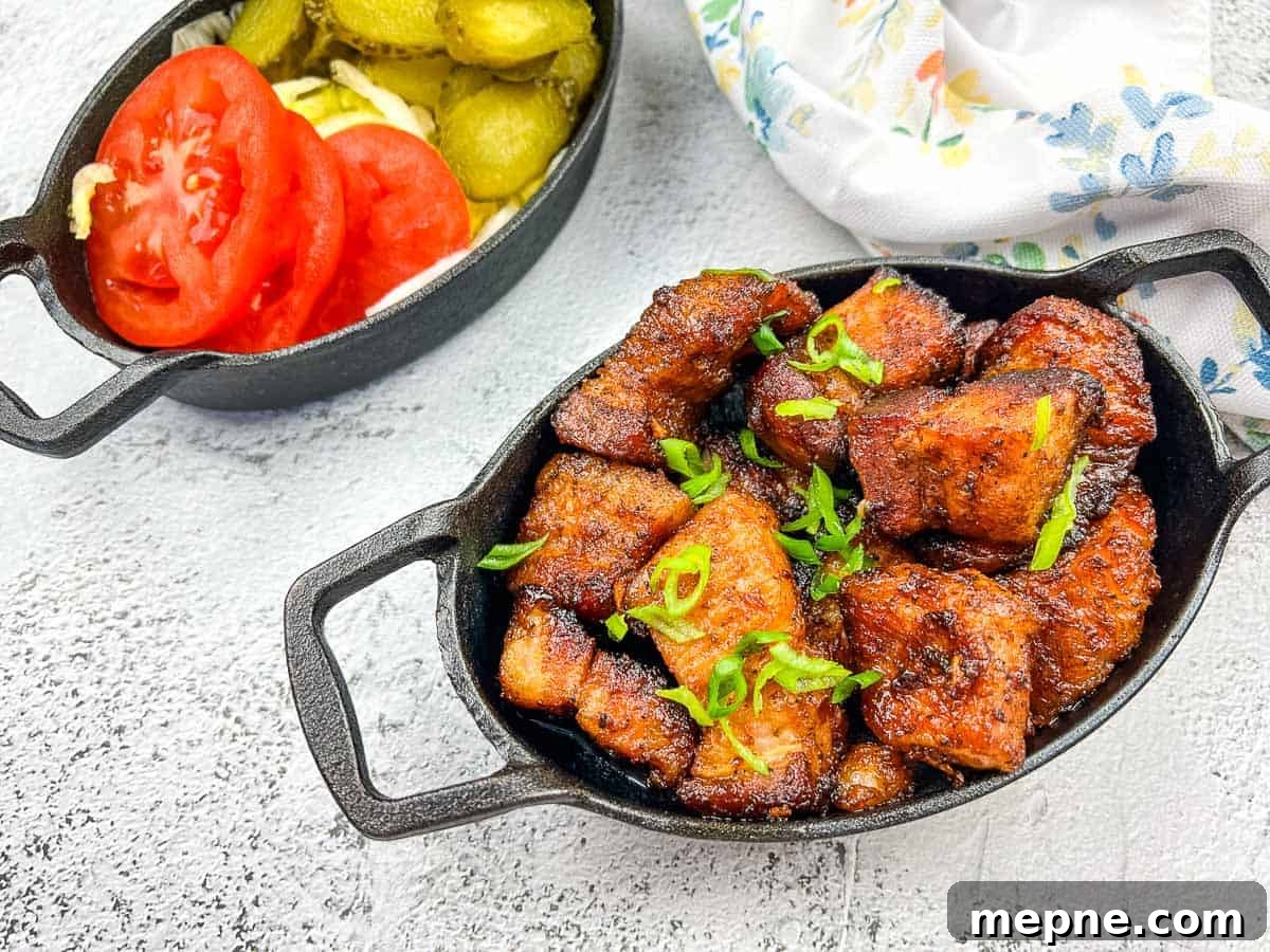31 Southern Recipes That Belong in Your Dinner Rotation 27 A plate of smoked pork belly burnt ends with tomatoes and pickles.
