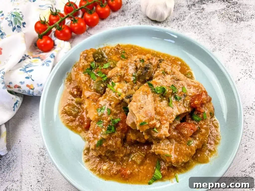 31 Southern Recipes That Belong in Your Dinner Rotation 30 Slow Cooker Swiss Pork Chops on a baby blue serving dish.