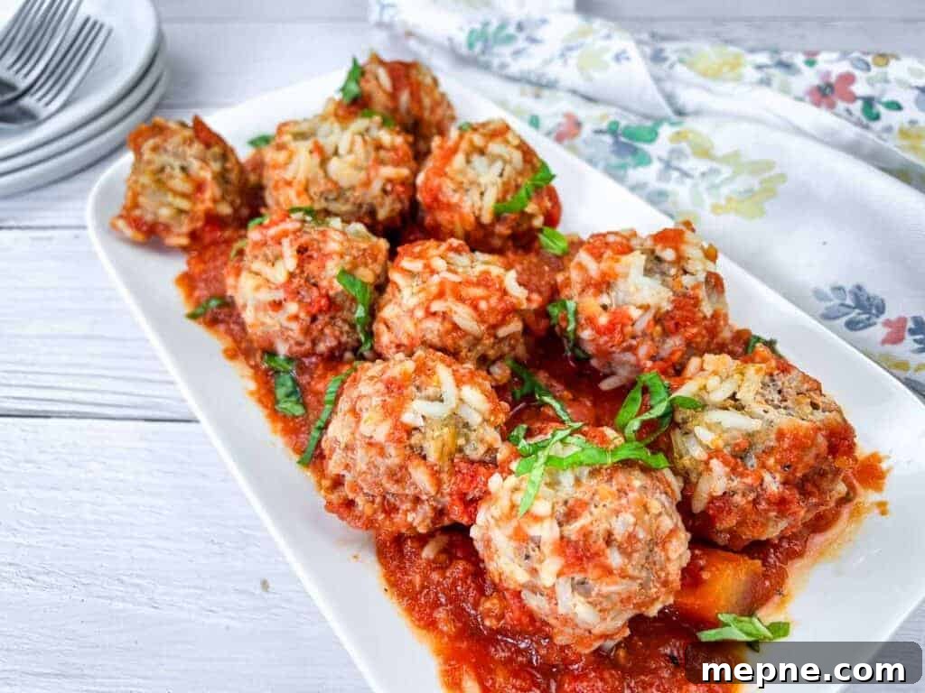 31 Southern Recipes That Belong in Your Dinner Rotation 10 A white rectangular plate with slow cooker porcupine meatballs, garnished with fresh herbs.