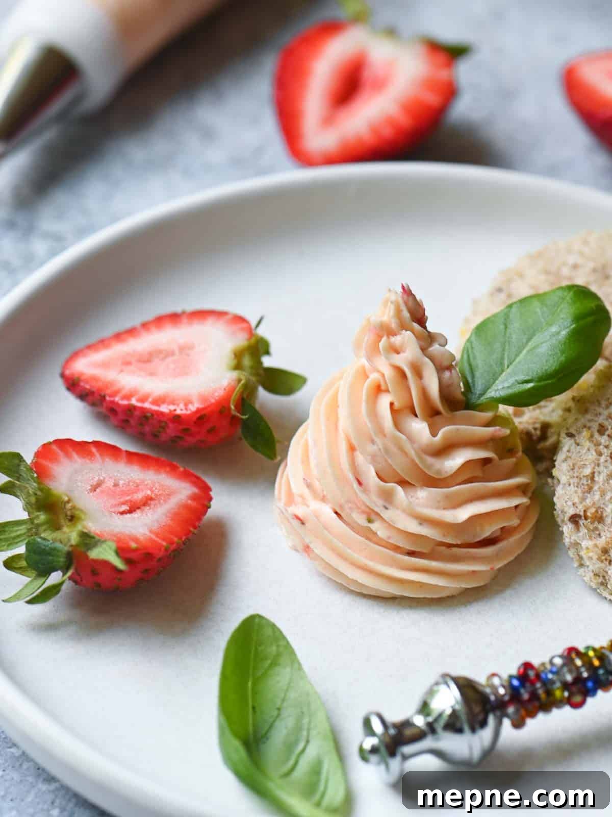Whipped Strawberry Butter with Fresh Basil Recipe 2 Whipped strawberry butter in a white plate with strawberries.