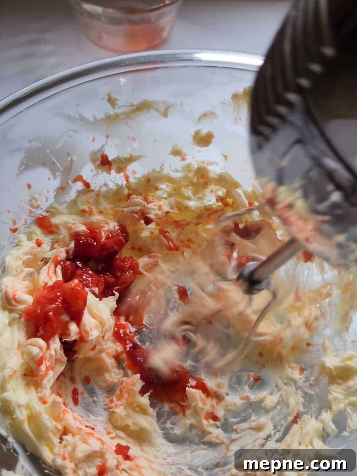 Whipped Strawberry Butter with Fresh Basil Recipe 6 Strawberries being mixed into butter with an electric beater.