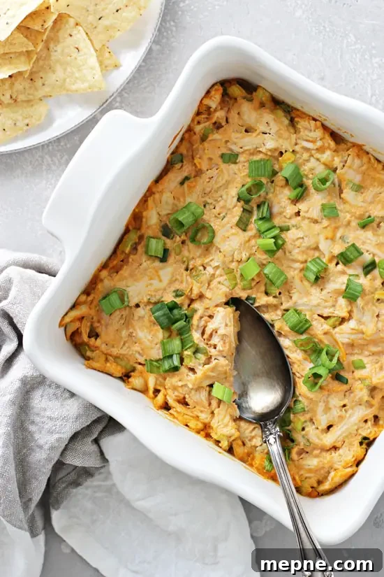 Non dairy buffalo chicken dip served warm in a baking dish with a spoon. Non Dairy Buffalo Chicken Dip in a baking dish with a spoon.