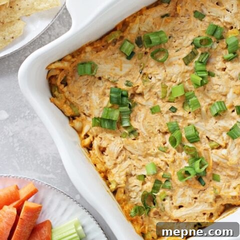 Dairy Free Buffalo Chicken Dip Recipe 2 Dairy Free Buffalo Chicken Dip in a baking dish with chips & veggies to the side.