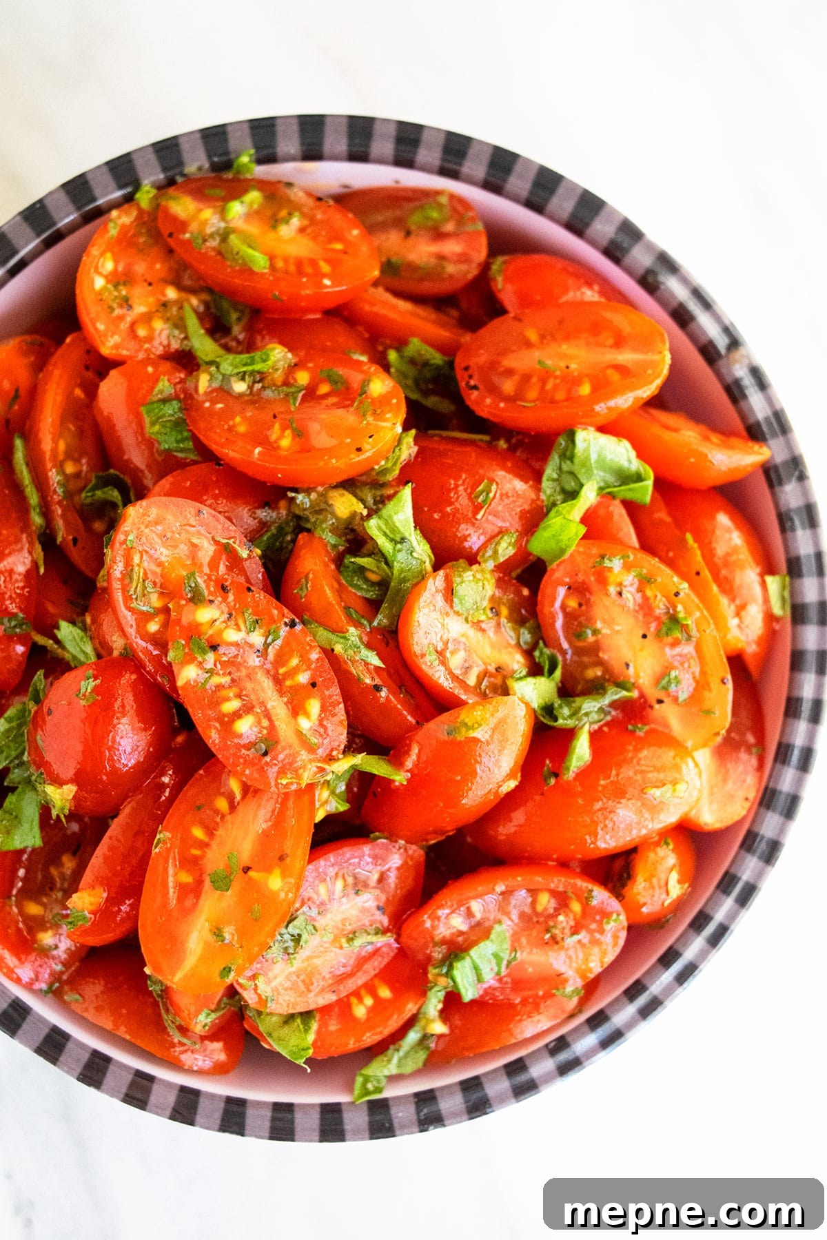 Easy homemade marinated tomatoes in black and white striped bowl- Overhead shot.