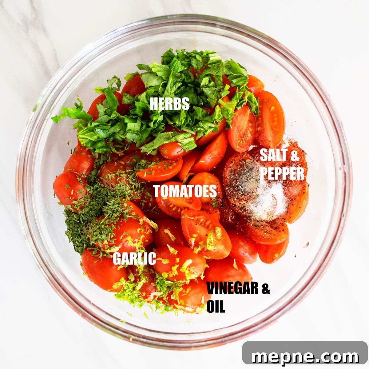 Ingredients in a glass bowl on white marble background ready to be tossed.