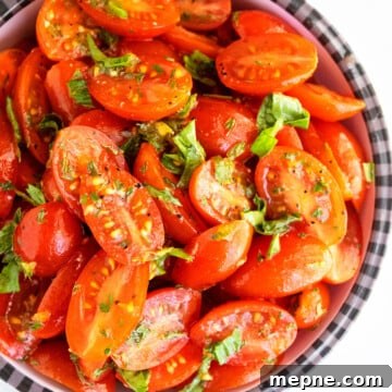 Best easy homemade marinated tomatoes with fresh herbs and spices in black and white bowl.