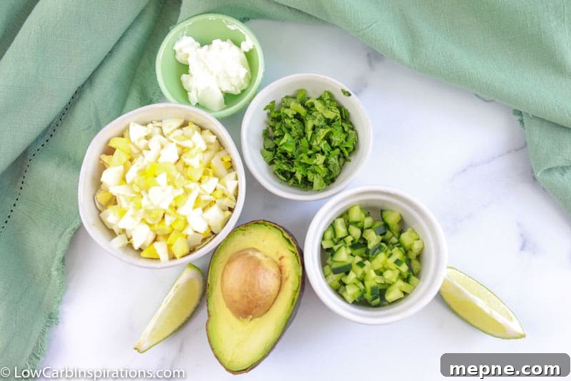 avocado egg salad recipe ingredients on a table with a towel in the background