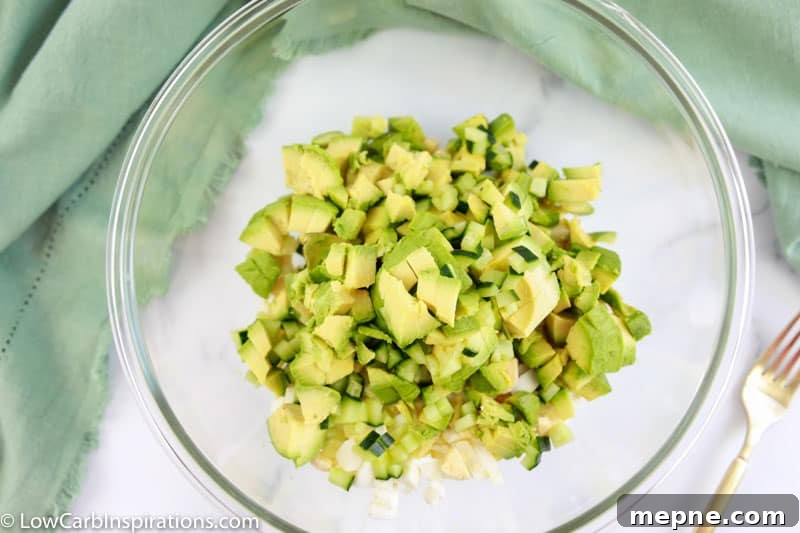 mashed avocado and eggs in a clear mixing bowl