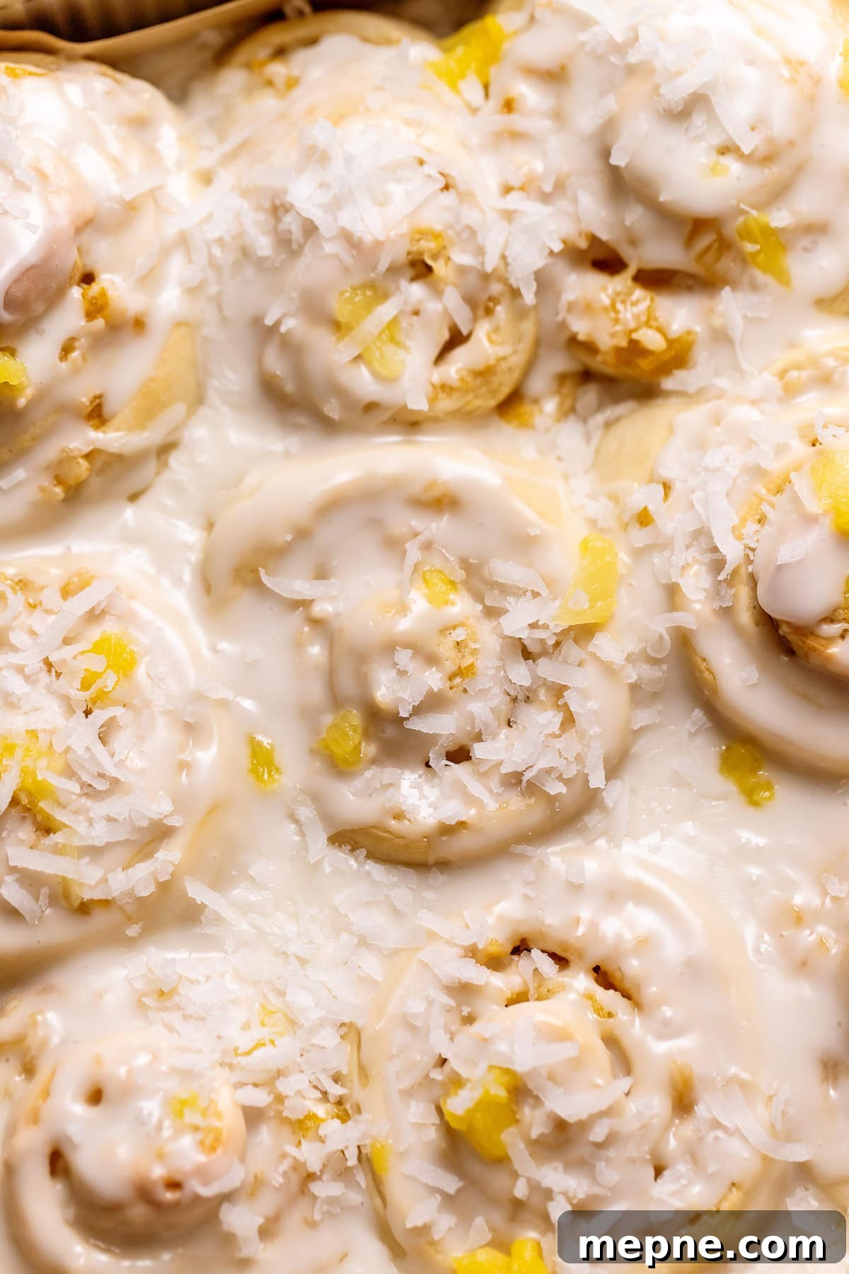 Tropical Pina Colada Cinnamon Rolls with Coconut Rum Icing 2 Pina colada cinnamon rolls topped with coconut and pineapple.