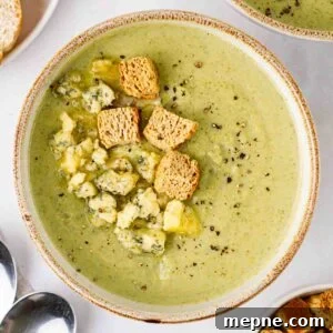 Creamy Broccoli and Stilton Soup Recipe 12 A big bowl of Broccoli and Stilton Soup on a white table.