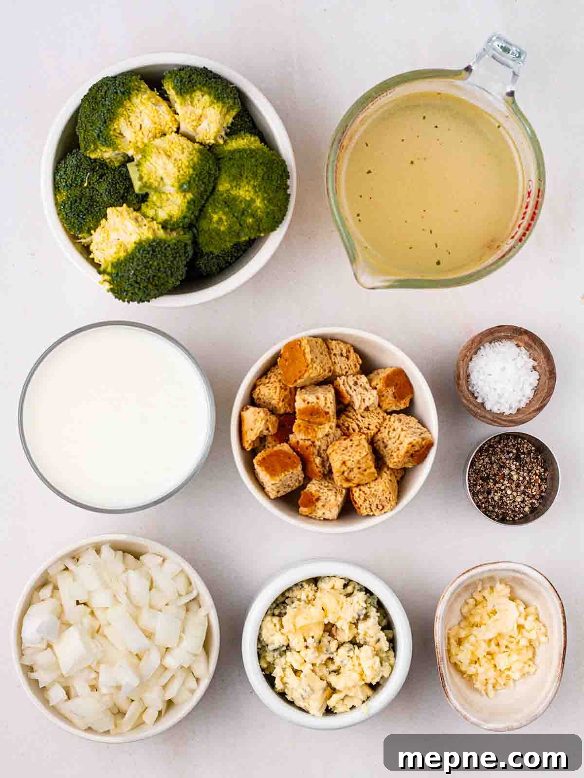 Creamy Broccoli and Stilton Soup Recipe 3 The ingredients for making Broccoli and Stilton Soup laid out in bowls on a white counter top.