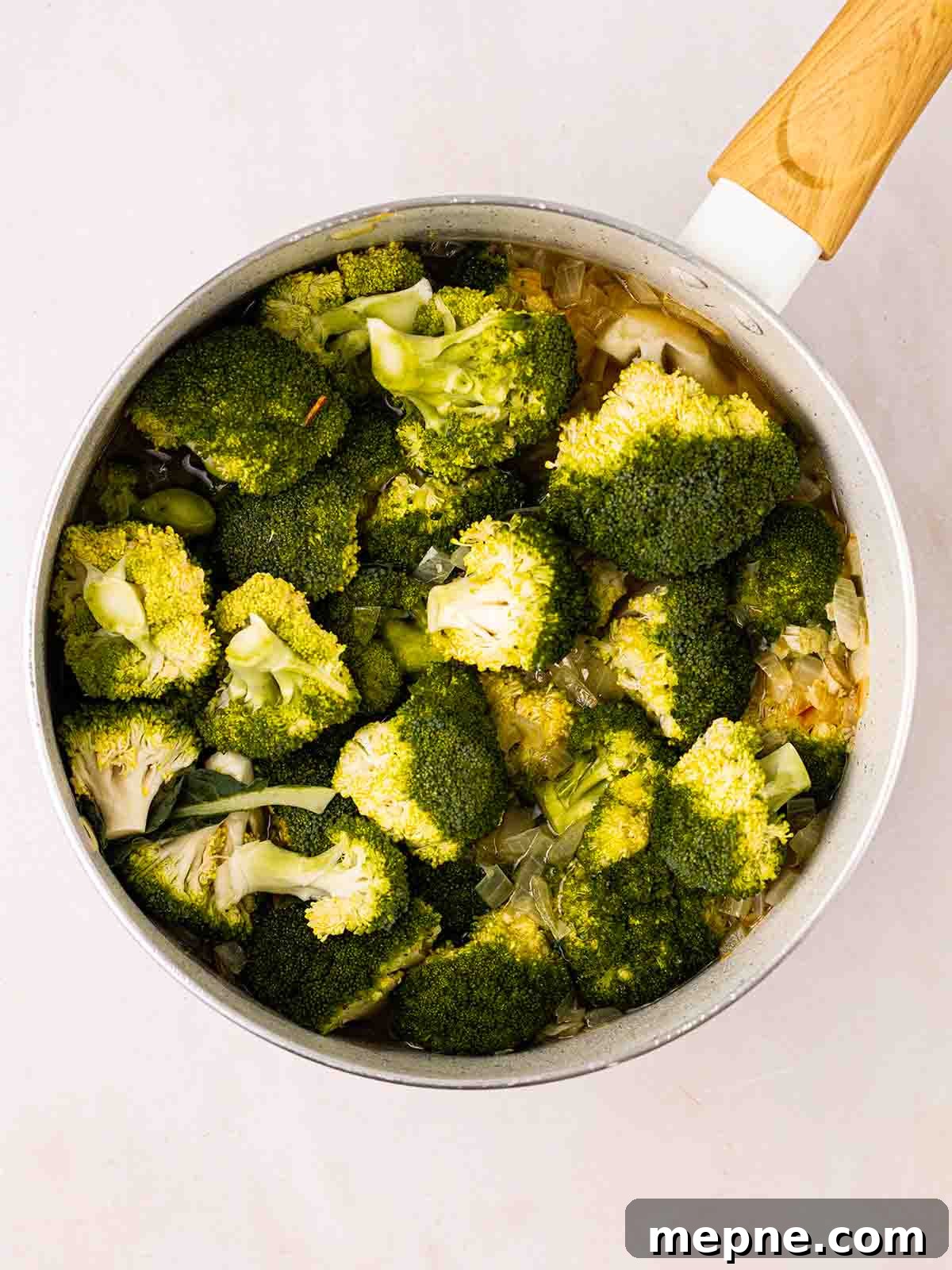 Creamy Broccoli and Stilton Soup Recipe 5 A pan filled with broccoli and onions for Broccoli and Stilton Soup recipe.