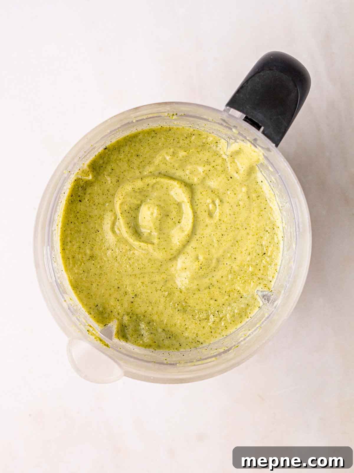 Creamy Broccoli and Stilton Soup Recipe 6 An electric blender with green Broccoli and Stilton Soup inside for step 3 in the recipe.