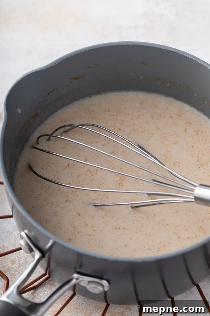 Saucepan with maca coffee and a whisk