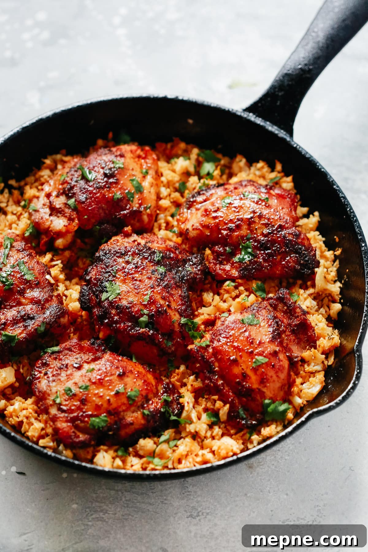 Keto Dinner Recipes: Low-Carb Ideas for Weeknights 13 close-up of chicken thighs and cauliflower rice in a cast iron skillet